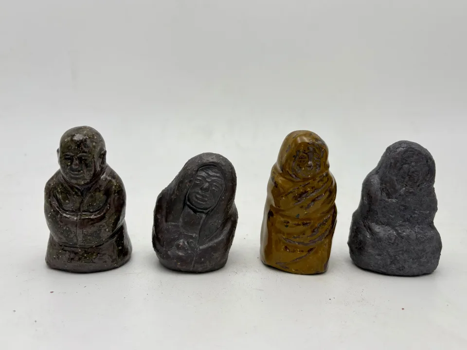 Four more: a bald monk with folded hands, two hooded figures, one in amber glaze.