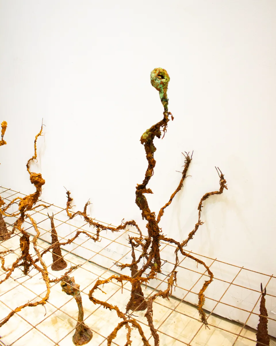 Detail: a single stem with a green, hollowed head above the grid of figures.
