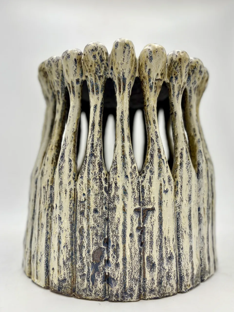 The vessel from the front on white: a slatted body of stems rising to the crown of heads.
