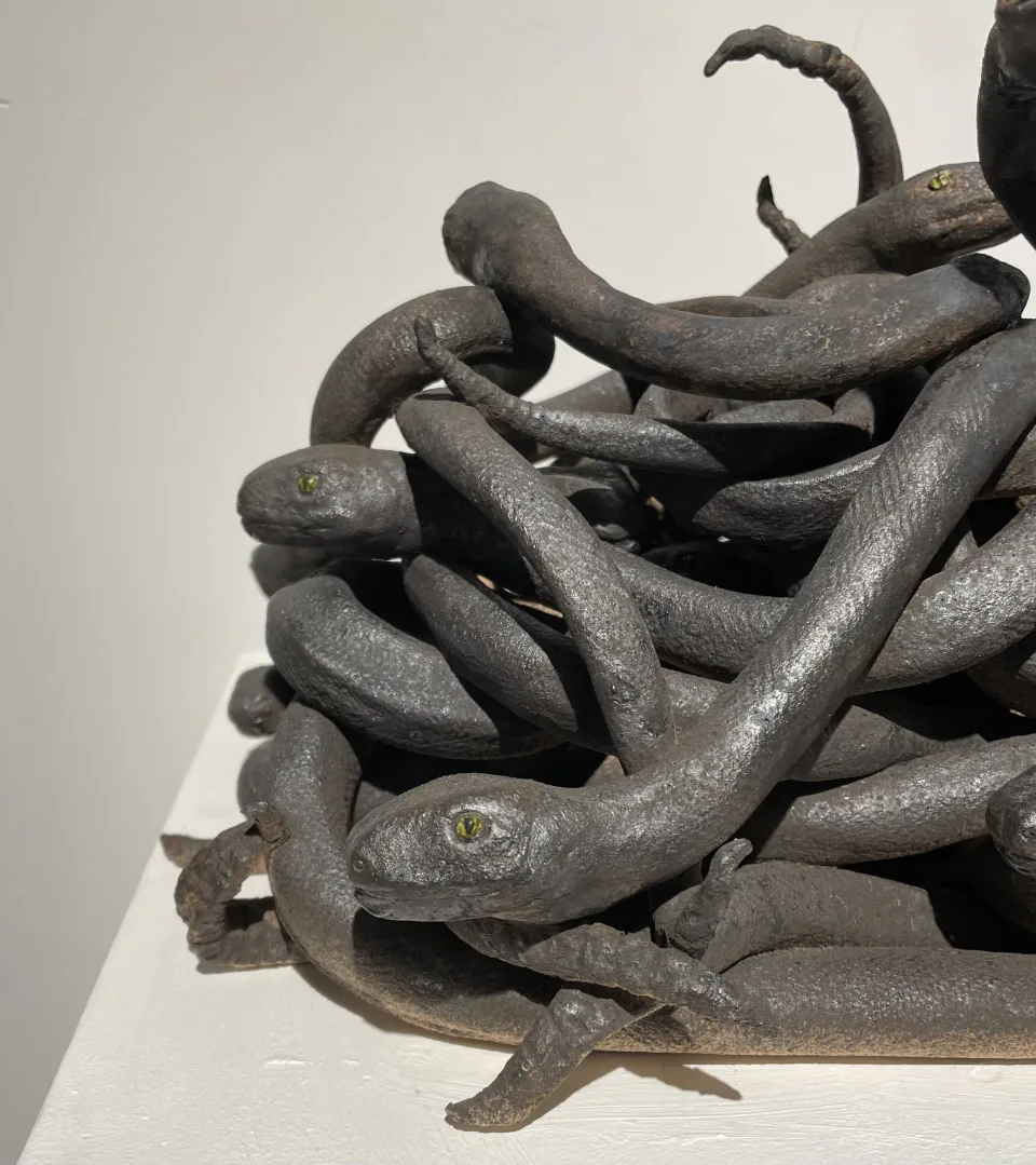 Detail: snakes coiled over one another, a head at the edge of the pile.
