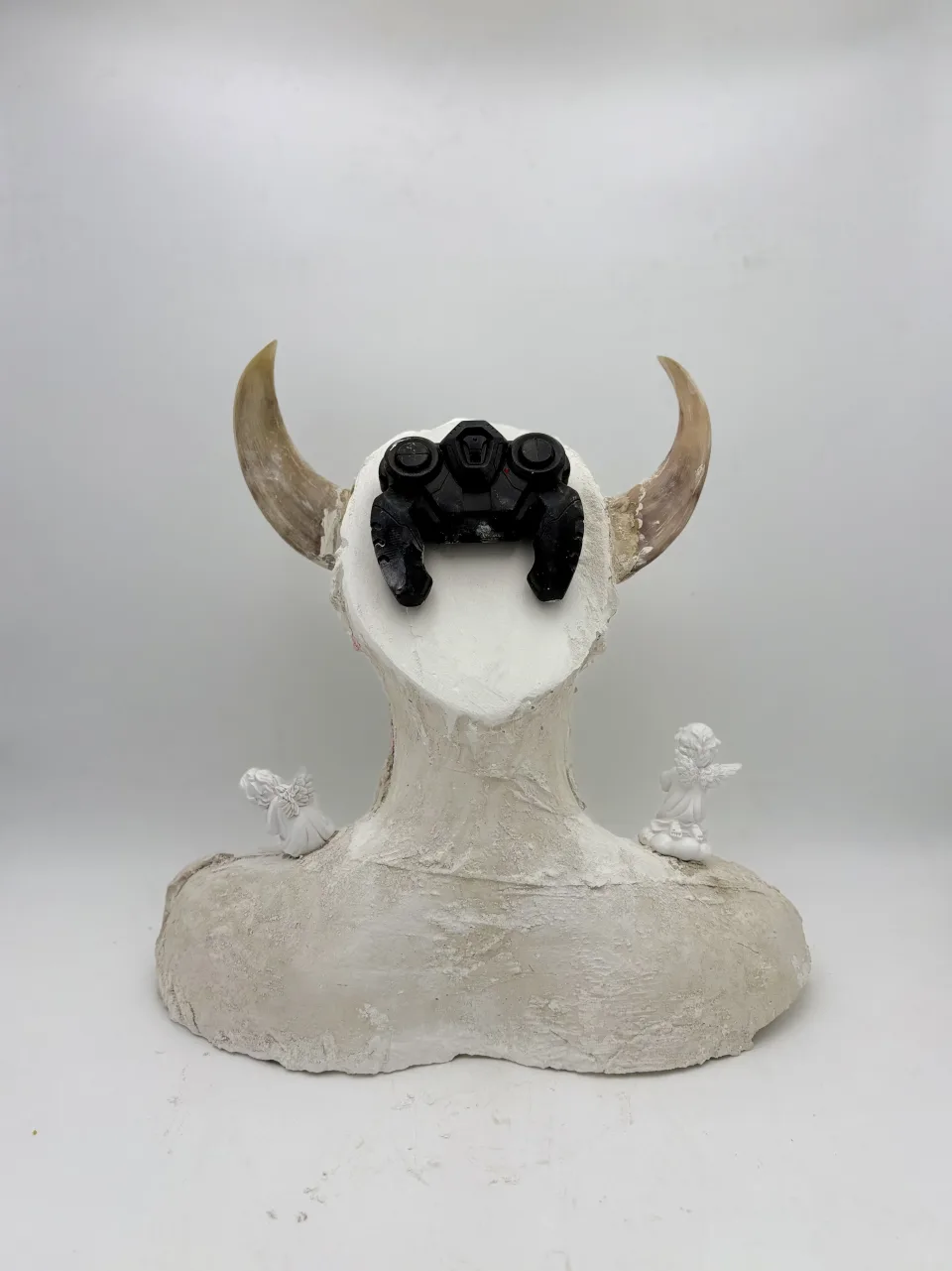 The bust from behind: a black game controller fixed to the back of the head between the horns.