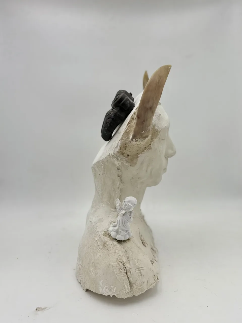 In profile: one horn, the controller behind the ear, an angel on the shoulder.